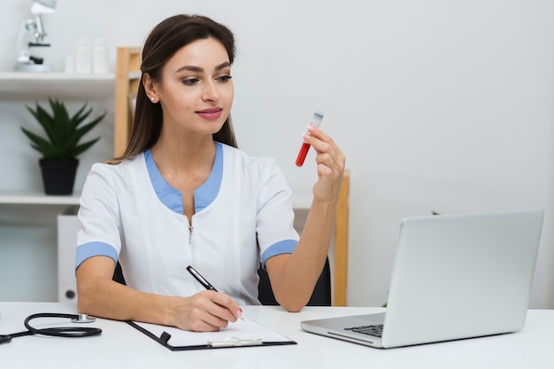 Medico sorridente che esamina un campione di sangue