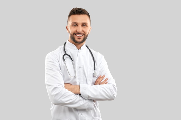 Medico sorridente con stretoscopio isolato su grigio