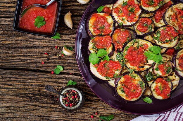 Melanzane grigliate con salsa di pomodoro, aglio, coriandolo e menta. Cibo vegano. Melanzane Alla Griglia. Vista dall'alto. Disteso