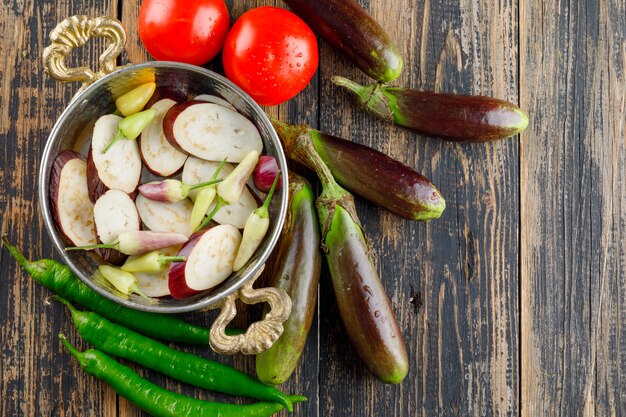 Melanzane in una padella con pomodori, peperoni piatto giaceva su un legno