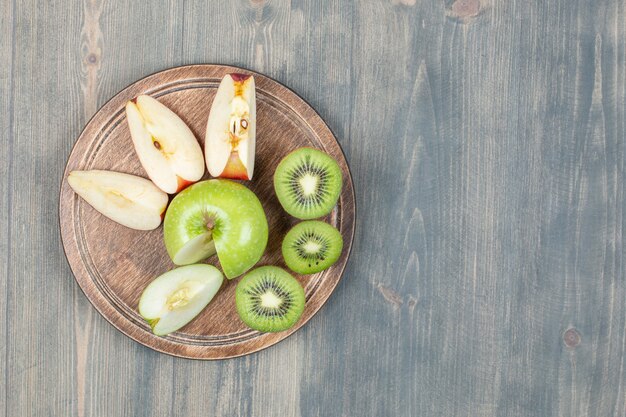 Mele a fette con kiwi fresco su un tavolo di legno