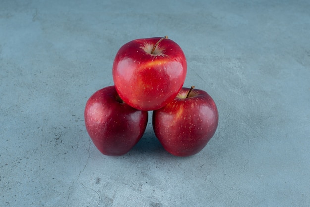 Mele dolci e rosse, sullo sfondo di marmo. Foto di alta qualità