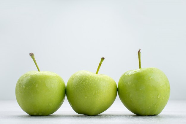 Mele verdi di vista frontale allineate sul pasto dell'alimento del succo molle della frutta bianca