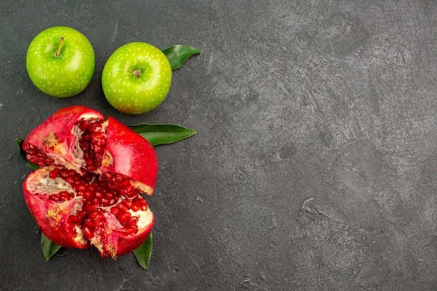Melograno fresco vista dall'alto con mele verdi su colore di frutti maturi superficie scura