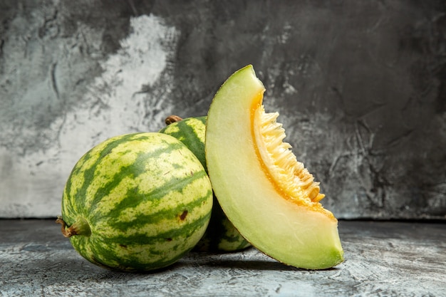 Melone fresco vista frontale con anguria sullo sfondo scuro-chiaro