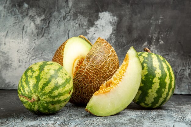 Melone fresco vista frontale con anguria sullo sfondo scuro-chiaro