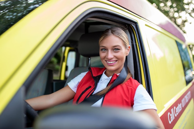 Membri del personale dell'ambulanza nella sua ambulanza Indossa l'uniforme dell'ambulanza dei paramedici È seduta nell'ambulanza pronta per andare a una chiamata