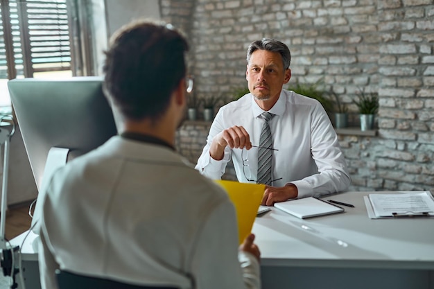 Membro del team delle risorse umane durante un colloquio di lavoro con un candidato in ufficio