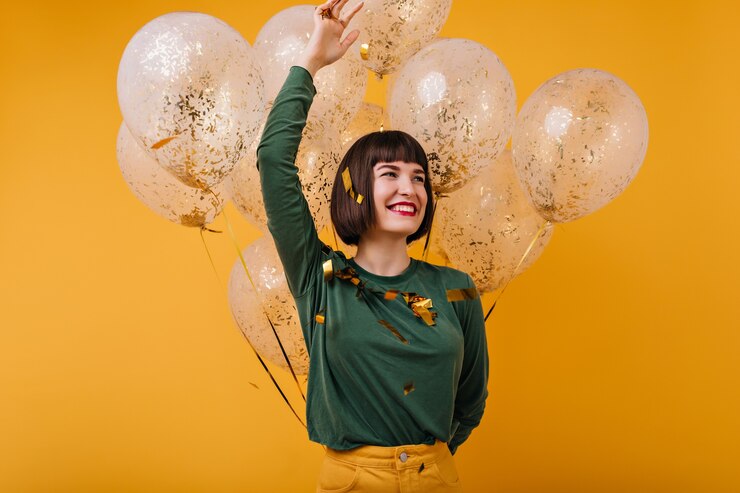 Foto gratuito meravigliosa giovane donna in posa emotivamente nel suo compleanno. ragazza dai capelli neri che ride godendo della festa.