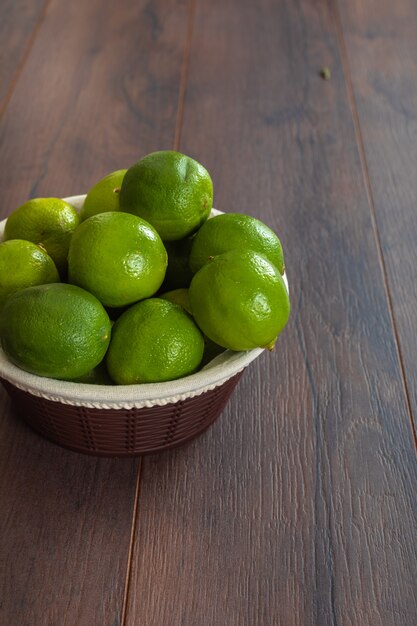 Merce nel carrello verde dei limoni sulla tavola marrone