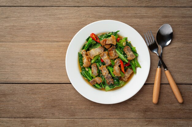 Mescolare cavolo fritto, carne di maiale croccante piccante sulla tavola di legno Concetto di cibo tailandese.