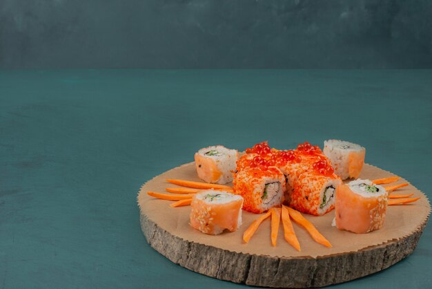 Mescolare il sushi con le fette di carota sulla tavola di legno.