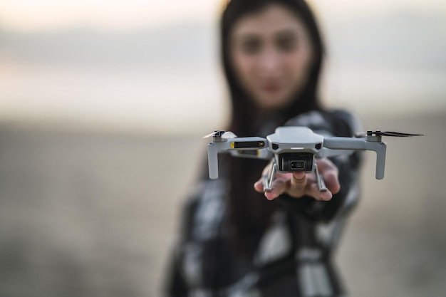 Messa a fuoco selettiva del drone sulla mano di una giovane ragazza caucasica spagnola