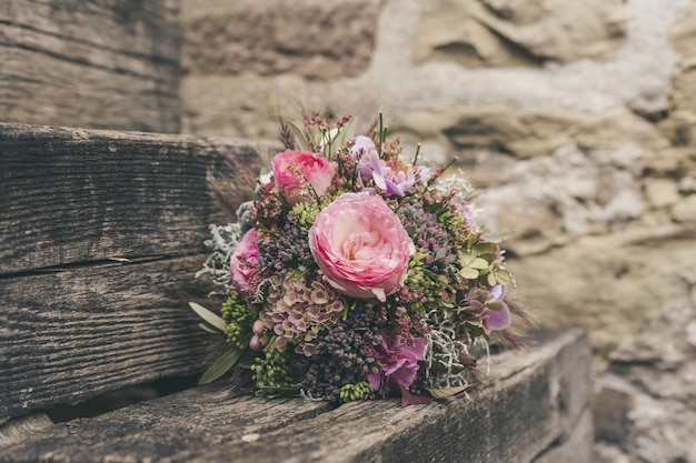 Messa a fuoco selettiva di un bellissimo bouquet di fiori piccoli su una superficie di legno