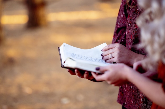 Messa a fuoco selettiva verticale di due donne che tengono un libro