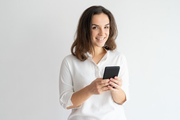 Messaggio di texting sorridente ragazza gioiosa o godendo nuova app.