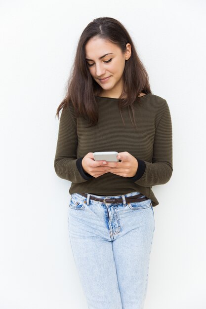 Messaggio mandante un sms pensieroso messo a fuoco della bella donna latina