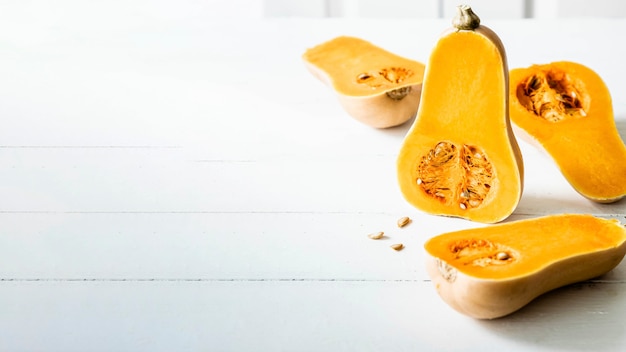 Metà della zucca butternut sulla tavola di legno bianca
