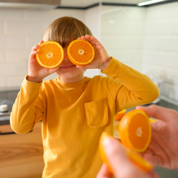 Metà di arance che coprono gli occhi
