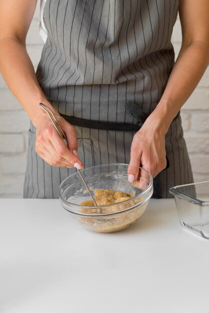 Metà di panettiere che schiaccia banana in ciotola