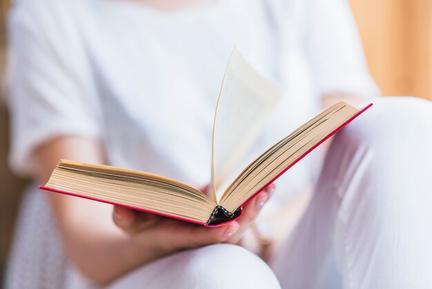 Metà di sezione del libro della holding della mano della donna