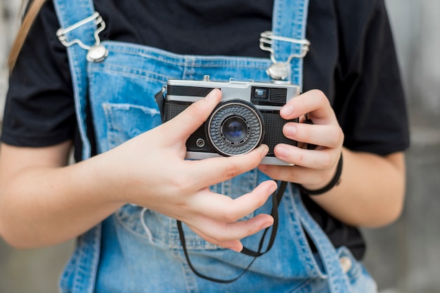 Metà di sezione della mano della ragazza che regola obiettivo di retro macchina fotografica