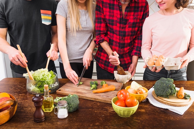 Metà di sezione di amici che preparano il cibo in cucina