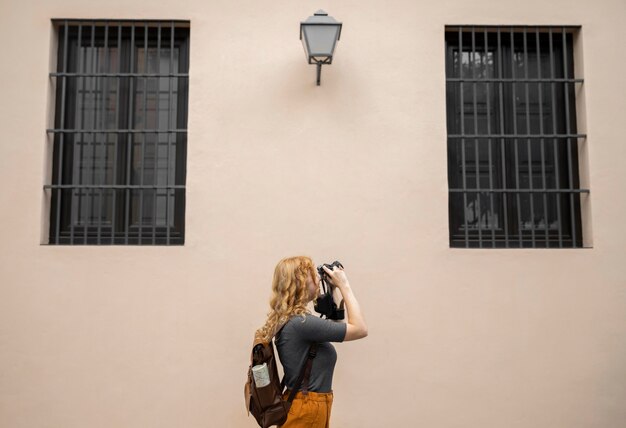 Metà donna corta che cattura foto con la macchina fotografica