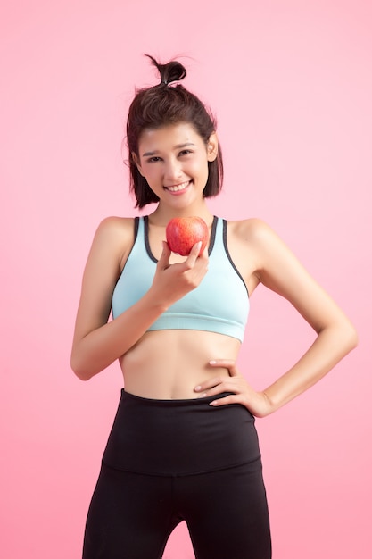 Metta in mostra la donna in buona salute che tiene una mela rossa