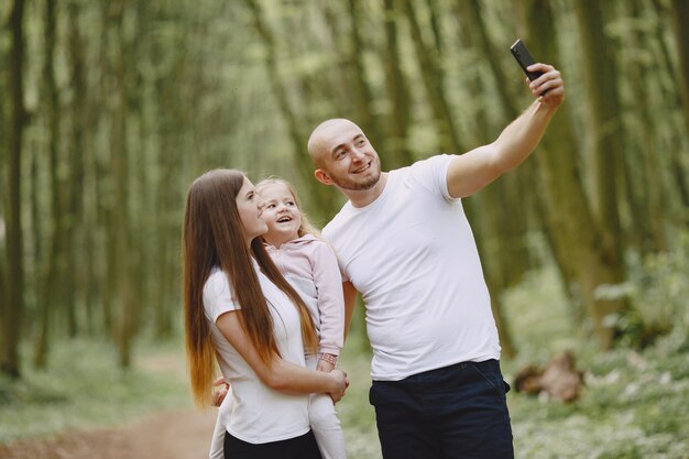 Mette in mostra la famiglia in una foresta dell'estate