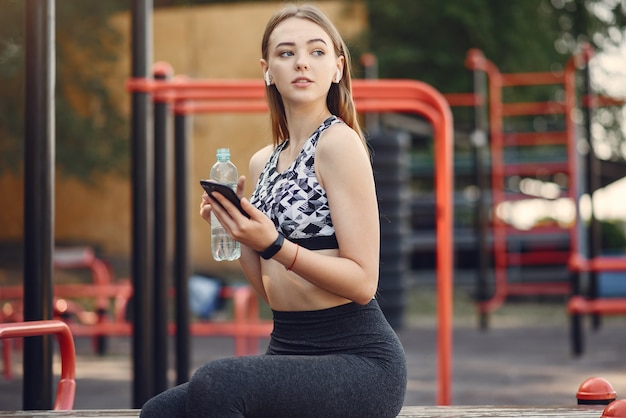 Mette in mostra la ragazza in un addestramento superiore nero in un parco dell'estate