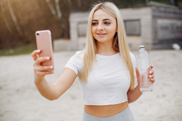 Mette in mostra la ragazza in un parco dell&#39;estate di mattina