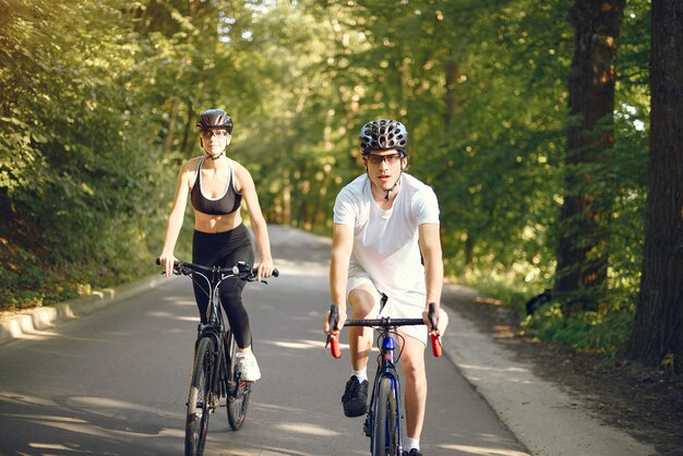 Mette in mostra le coppie che guidano le bici nella foresta dell'estate