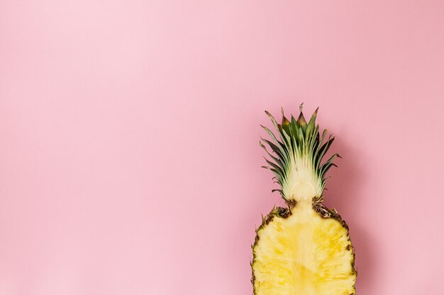 Mezza fetta di bella fresca appetitosa ananas gustosa su sfondo rosa. Vista dall&#39;alto. Orizzontale. Spazio di copia. Concettuale.