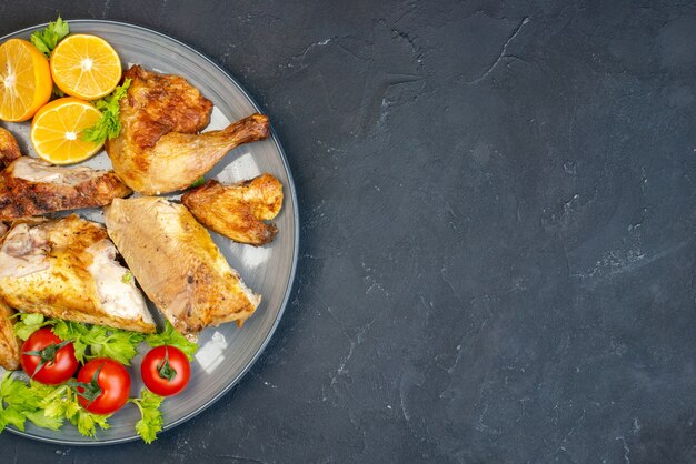 Mezza vista dall'alto pollo al forno pomodori freschi fette di limone?