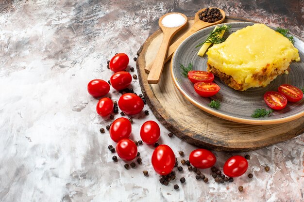 Mezza vista inferiore pomodori di pane di formaggio su piastra cucchiai di legno su tavola da portata rustica pomodorini su tavola copia posto table