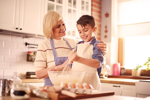 Mezzo busto di ragazzo e nonna in cucina