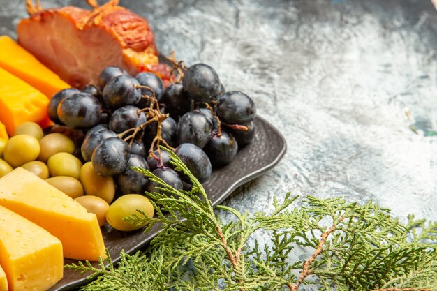 Mezzo colpo di gustoso spuntino migliore per il vino su vassoio marrone e rami di abete su sfondo di ghiaccio