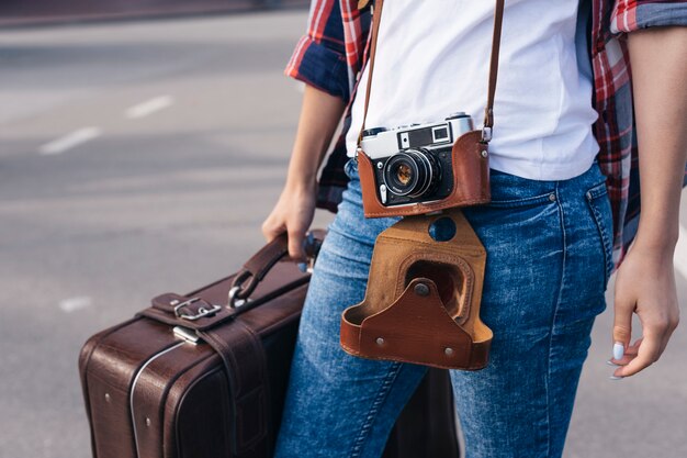 Midsection della borsa di trasporto dei bagagli del viaggiatore della giovane donna sulla via