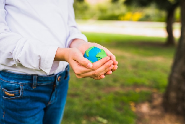 Midsection di un globo della holding della ragazza in mani a coppa