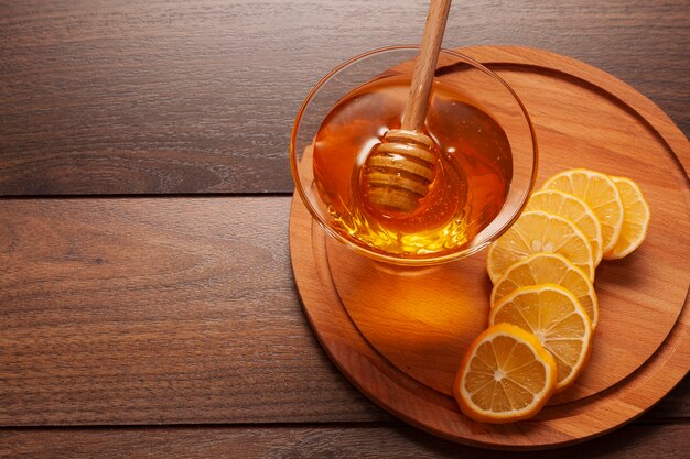 Miele delizioso del primo piano con le fette del limone