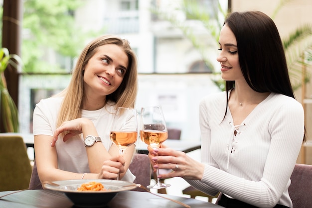 Migliori amiche che brindano con bicchieri di vino