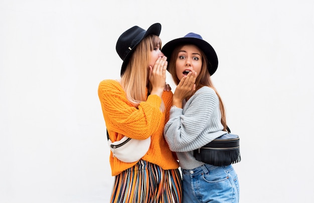 Migliori amiche, coppia di ragazze alla moda che posano sul bianco