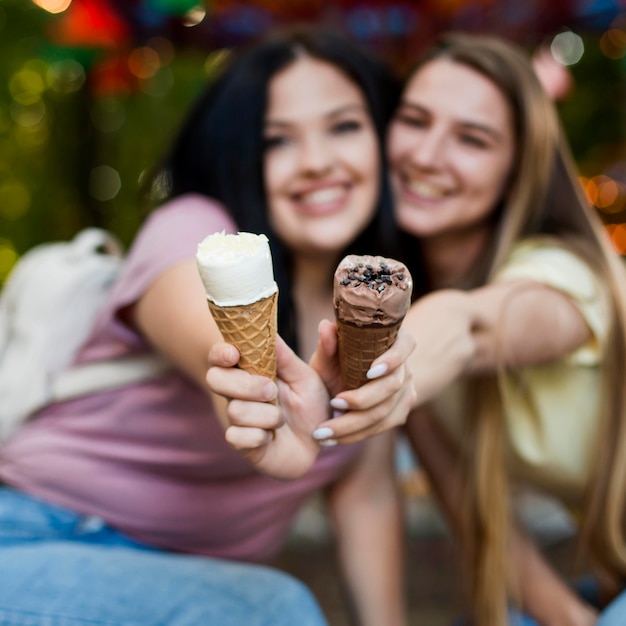 Migliori amiche del colpo medio che posano con il gelato