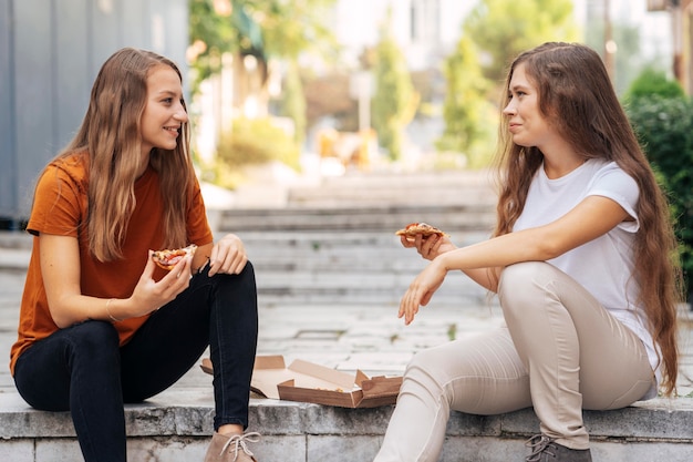 Migliori amici che mangiano una fetta di pizza