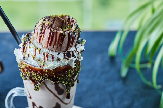 Milkshake con cono, cioccolato, spruzza nella superficie verde