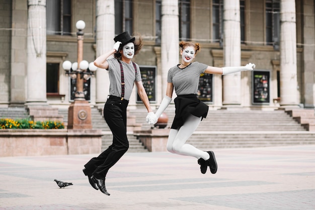 Mime coppia saltando di fronte all&#39;edificio