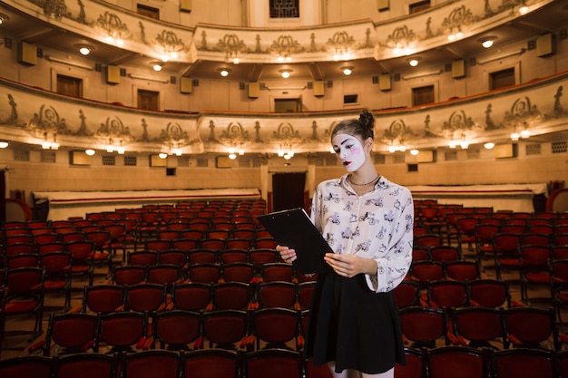 Mime femminile che sta nello scritto della lettura della sala