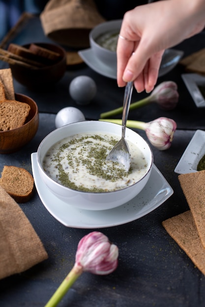 minestra di luce bianca dovga di verdure con erbe diverse su grigio