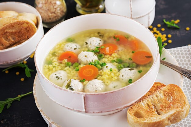 Minestra italiana della polpetta e pasta di Stelline in ciotola sulla tavola nera. Zuppa dietetica Menu per bambini. Cibo gustoso.